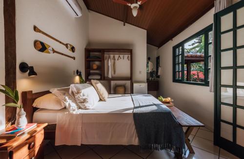 a bedroom with a bed and a window at Pousada Vila das Pedras in Ilhabela