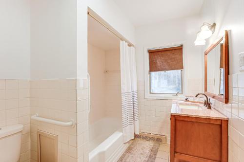 a bathroom with a tub shower and a sink at 3 Mi to Duck Lake State Park Home with Deck! in Muskegon