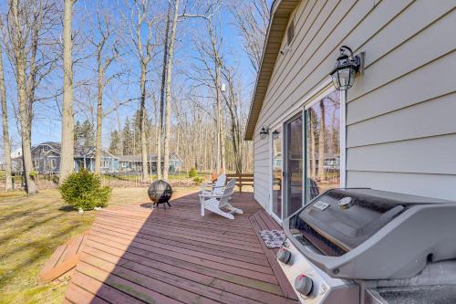 a grill on a wooden deck next to a house at 3 Mi to Duck Lake State Park Home with Deck! in Muskegon