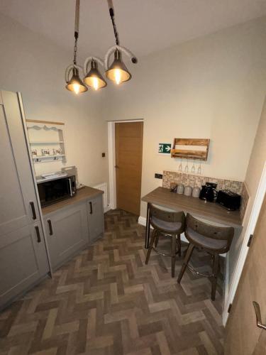 a kitchen with a table and chairs in a room at Fadó & Tide Apartments in Filey