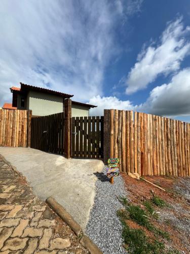 a fence in front of a house next to a house at Chalé Alto do Valle in Paty do Alferes