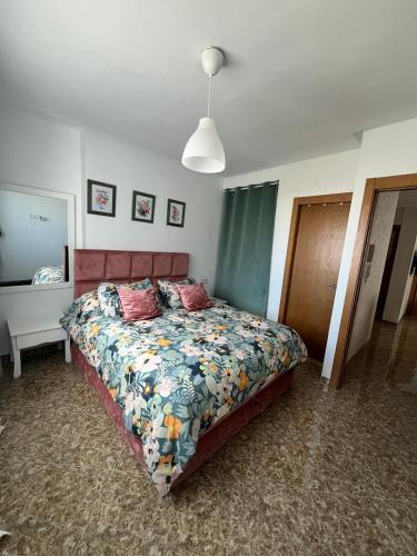 a bedroom with a bed with a floral comforter at oued laou Mekkad in Oued Laou