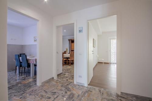 a living room with white walls and a dining room at Magnolia House in Fonte Nuova
