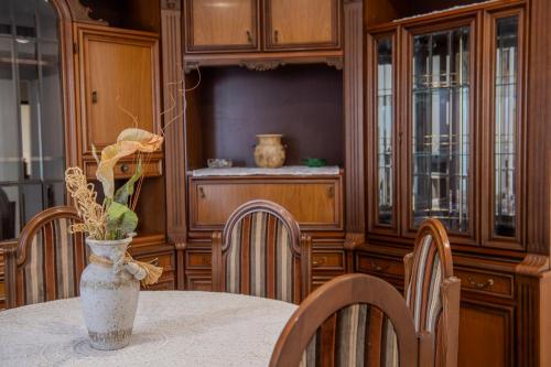 a dining room with a table and chairs and a vase with flowers at Magnolia House in Fonte Nuova