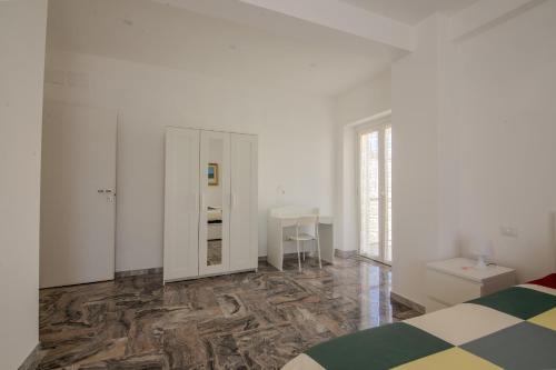 a white room with a bed and a mirror at Magnolia House in Fonte Nuova