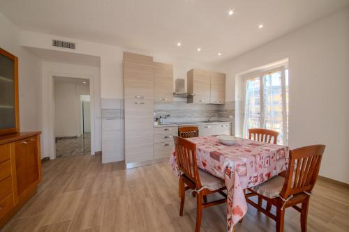 a kitchen with a table and chairs with a pink table cloth at Magnolia House in Fonte Nuova