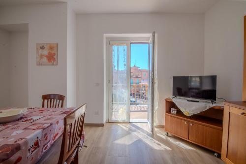 a bedroom with a bed and a tv and a sliding glass door at Magnolia House in Fonte Nuova