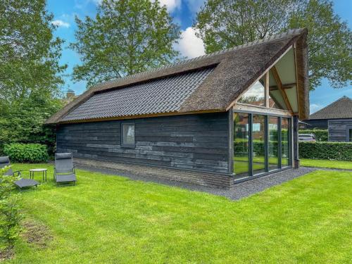 a small house with a pitched roof on a lawn at Villa Brocante in Alphen