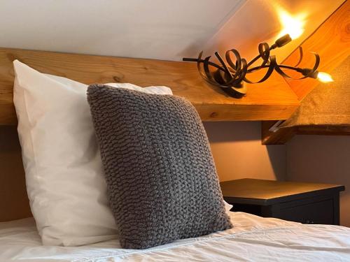 a pillow on a bed with a wooden headboard at Villa Brocante in Alphen