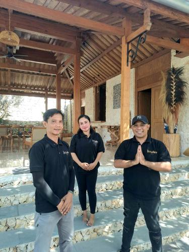 three men in black shirts standing in front of a building at Imalee - Cottage in Yogyakarta