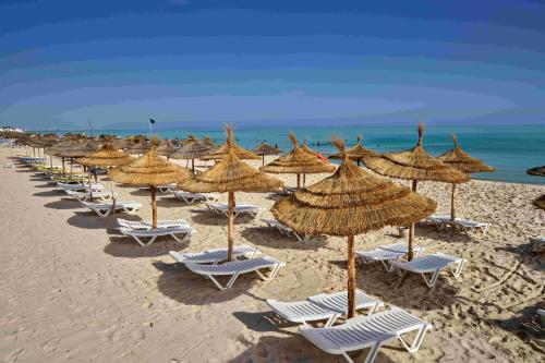 a row of chairs and umbrellas on a beach at TUI SUNEO Palm Beach Skanes - All Inclusive in Monastir