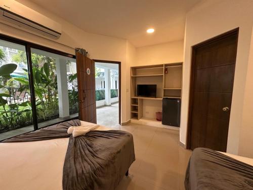 a bedroom with a bed and a large glass door at Wide Mouth Frog Quepos in Manuel Antonio