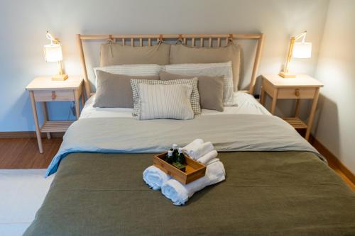 - un lit avec des serviettes et une boîte en bois dans l'établissement Beachfront Costa Nova Villa - 3 BR Apartment, à Gafanha da Encarnação