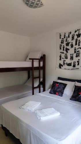 a bedroom with a bed and a bunk bed at Pousada Preguiça in Canoa Quebrada
