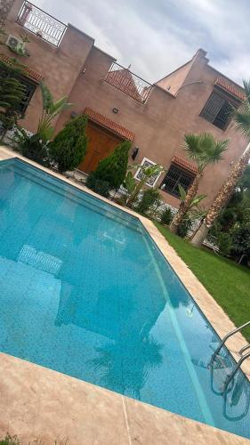 a large blue swimming pool in front of a building at Villa haut standig 2000 m2 in Marrakesh