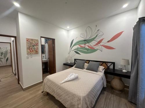 a bedroom with a bed with a flower mural on the wall at Wide Mouth Frog Quepos in Manuel Antonio