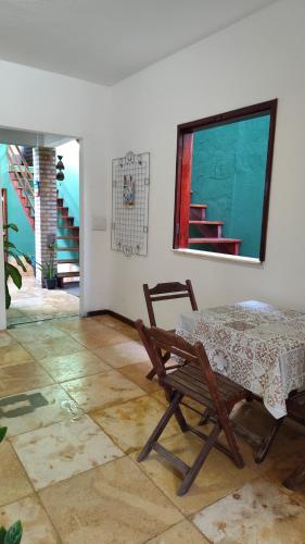 a dining room with a table and a chair at Pousada Preguiça in Canoa Quebrada