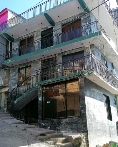 an apartment building with a balcony on top of it at Mount Murree Hotel in Murree