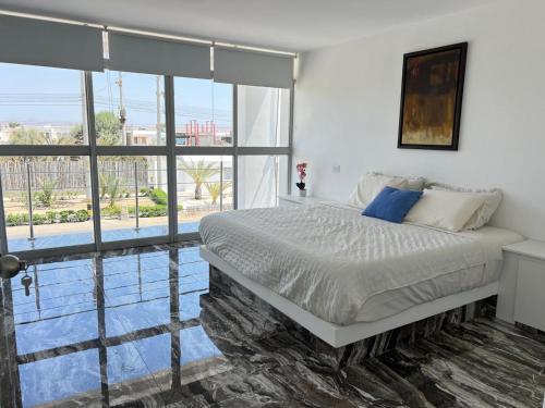 パラカスにあるCasa Monet Residential Paracasの大きなベッドと大きな窓のある寝室