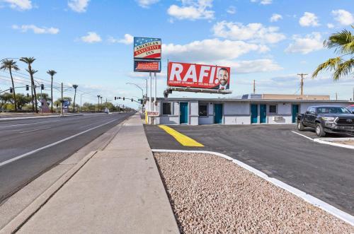 a road with a building with a rita sign on it at American Executive Inn Mesa in Mesa