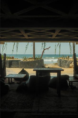 a table with a view of the beach and the ocean at Samas Lasal - Hotel La Saladita in Temalhuacán