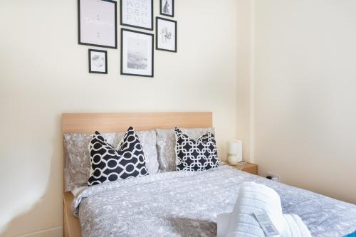 a bedroom with a bed with black and white pillows at Tower Bridge Home in London
