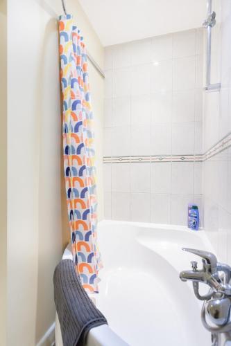a bathroom with a bath tub and a sink at Tower Bridge Home in London