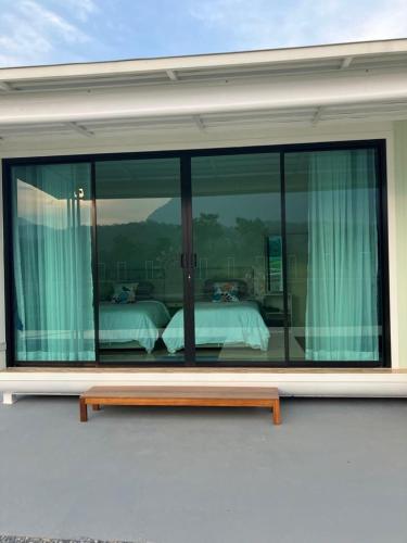 a room with a large glass window with a bed at The Rice Chiang Dao in Ban Thung Lakhon