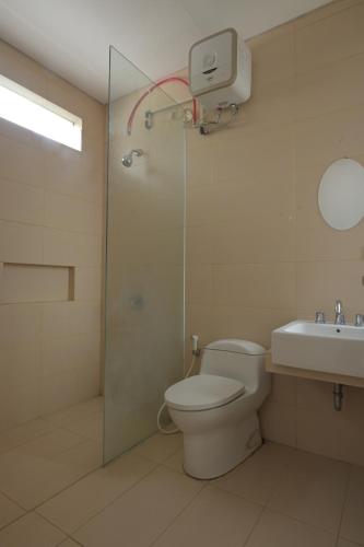 a bathroom with a shower and a toilet and a sink at GreenLake Vista in Surabaya