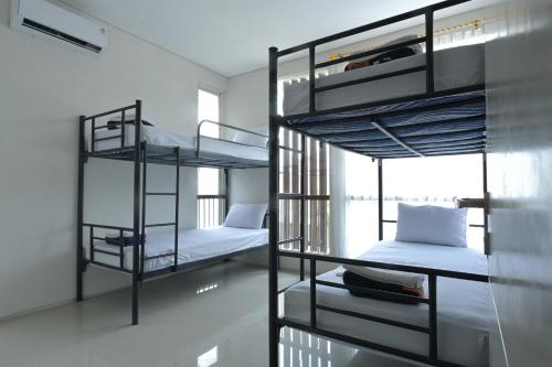 two bunk beds in a room with a window at GreenLake Vista in Surabaya