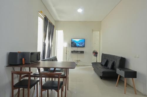 a living room with a table and chairs and a couch at GreenLake Vista in Surabaya