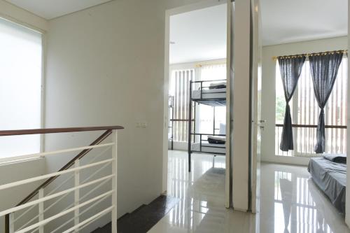 a room with white walls and a staircase with windows at GreenLake Vista in Surabaya