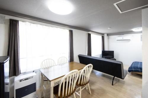 a living room with a dining room table and chairs at Meteore琴似 in Sapporo