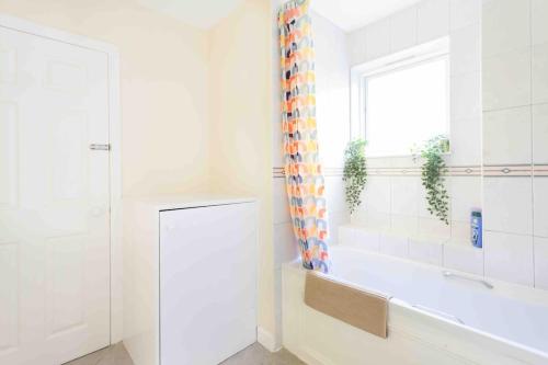 a white bathroom with a tub and a window at Tower Bridge Home in London