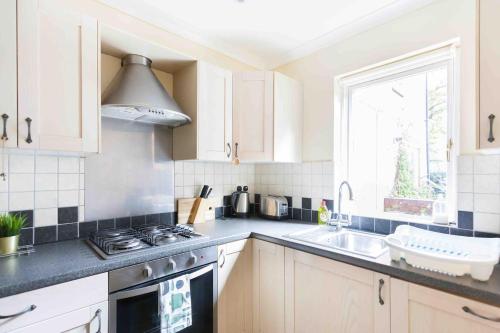 a kitchen with a stove and a sink and a window at Tower Bridge Home in London