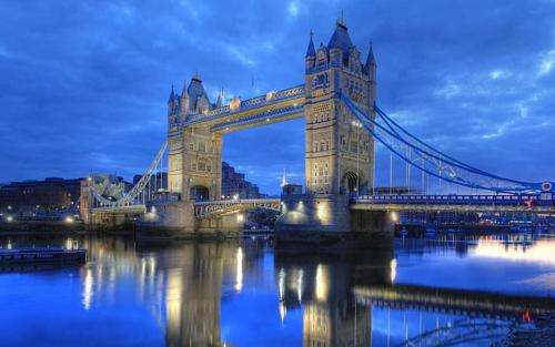 a suspension bridge over the water at night at Tower Bridge Home in London
