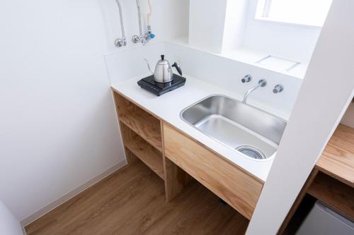 a bathroom with a sink and a mirror at イリゴアパートメントホテル in Hirosaki