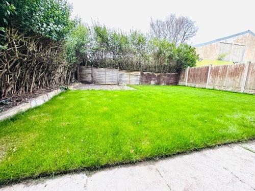 a yard with green grass and a fence at 224 Newcastle Street in Stoke on Trent