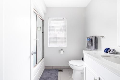 a white bathroom with a toilet and a sink at Luxury Downtown Townhome Private Garage Unit 3 in Cleveland