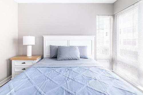 a white bedroom with a bed and a window at Luxury Downtown Townhome Private Garage Unit 3 in Cleveland