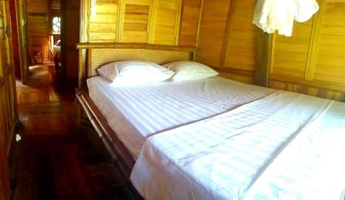 a bedroom with a bed with white sheets and pillows at Quế Homestay in Hòa Bình