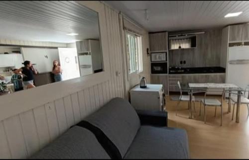 ein Wohnzimmer mit Sofa und eine Küche mit Personen in der Unterkunft House Tais in Gramado