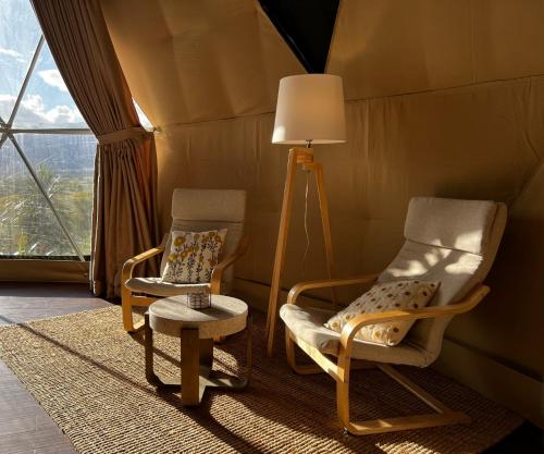 two chairs and a lamp in a room with a window at Hanmer Glamping in Hanmer Springs