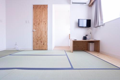 a room with a door and a rug on the floor at イリゴアパートメントホテル in Hirosaki