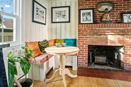 a living room with a table and a brick fireplace at Historic Downtown Berlin Home Dog Friendly Home in Berlin