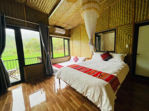 a bedroom with a large bed in a room with windows at Quế Homestay in Hòa Bình