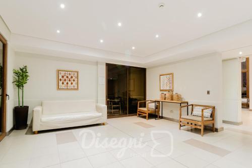ein Wohnzimmer mit einer weißen Couch und einem Tisch in der Unterkunft Disegni 02 - Departamento Av del Mar La Serena Sector Casino Enjoy in Coquimbo