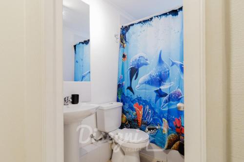 ein Bad mit einem Delfinduschvorhang und einem WC in der Unterkunft Disegni 02 - Departamento Av del Mar La Serena Sector Casino Enjoy in Coquimbo