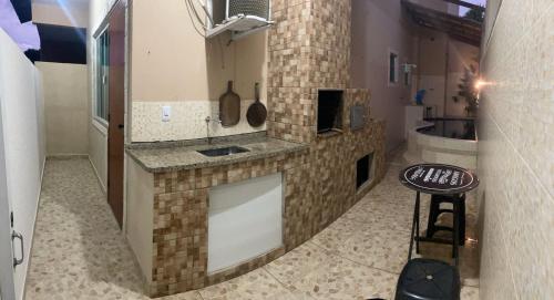 a kitchen with a counter and a stool in a room at Suíte 2 caminho do mirante in Iguaba Grande