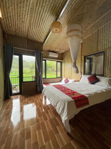 a bedroom with a large bed and a large window at Quế Homestay in Hòa Bình